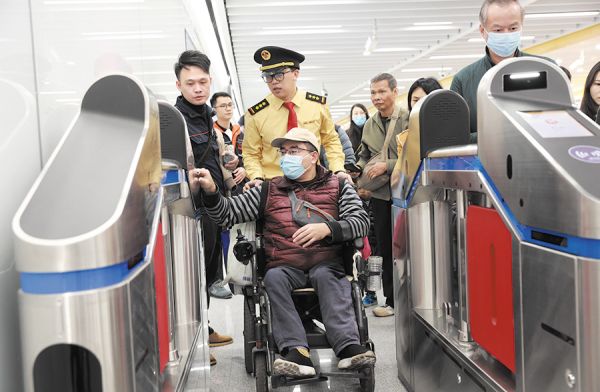 地铁工作人员帮助出行不便的旅客