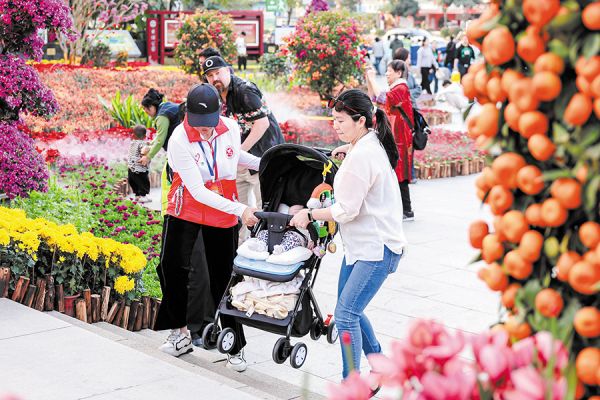 青年志愿者帮助市民将婴儿车抬上花市阶梯