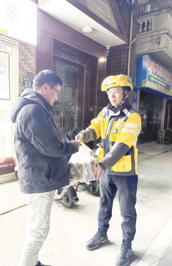 外卖员将温暖餐食送至顾客手中