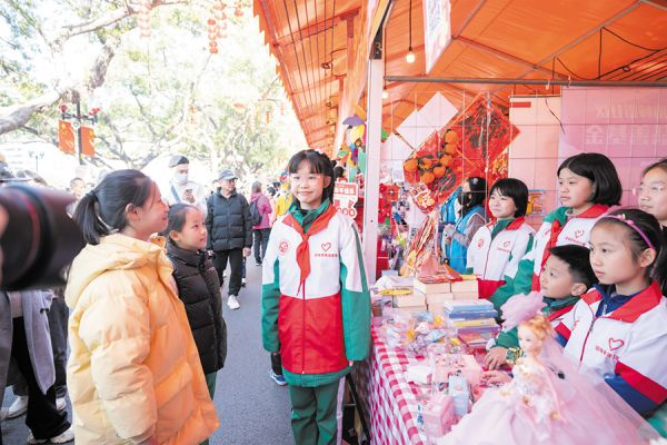 广州市执信中学琶洲实验学校学生志愿者在花市进行义卖(由通讯员供图)