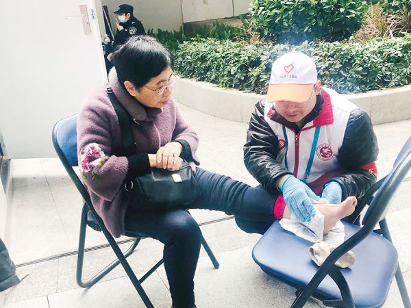 应急救护志愿者为旅客进行应急医疗处理